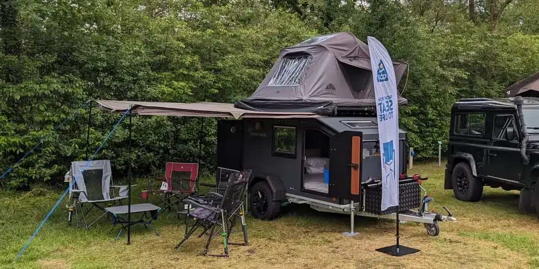 De Tasman met daktent en luifel op een veld